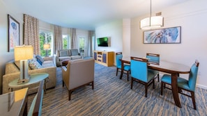 Une chambre d’hôtel comprenant un coin salon, une table à manger et un téléviseur.