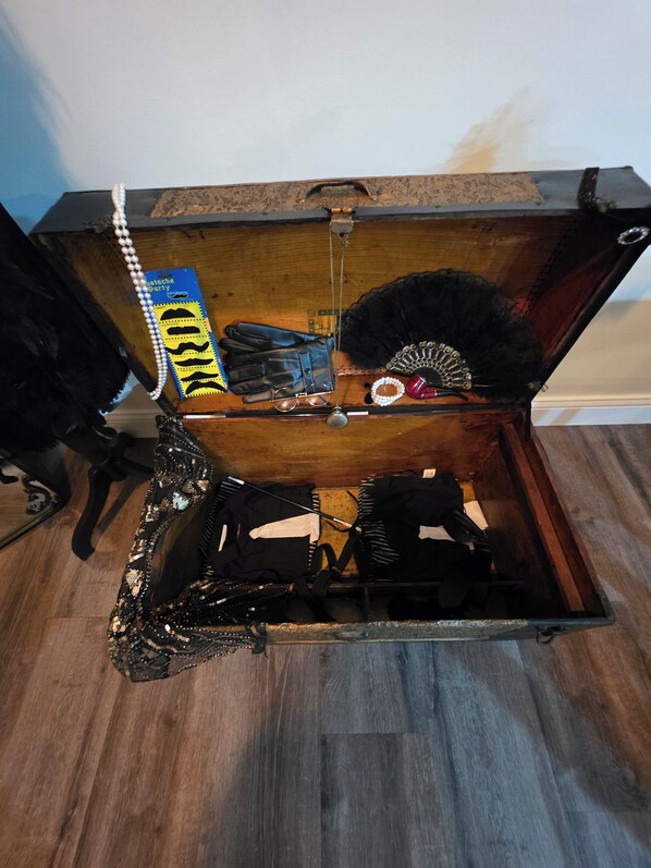 An open trunk with various items inside, including a belt, a pair of gloves, and a decorative item.