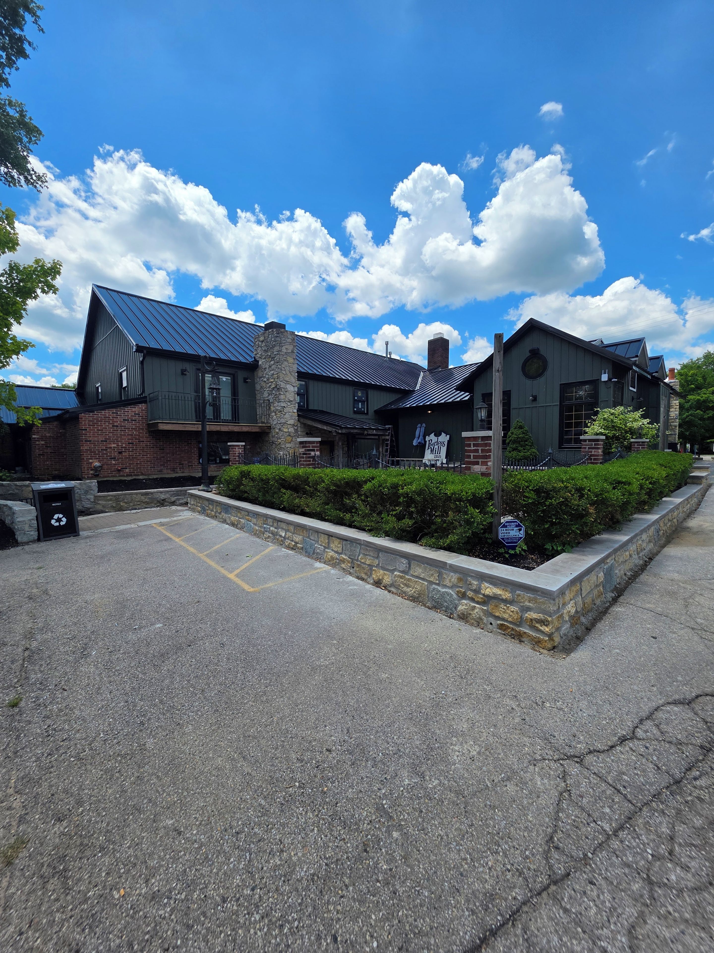A building with a brick facade, a stone chimney, and a metal roof.