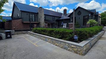 A building with a brick facade, a stone chimney, and a metal roof.