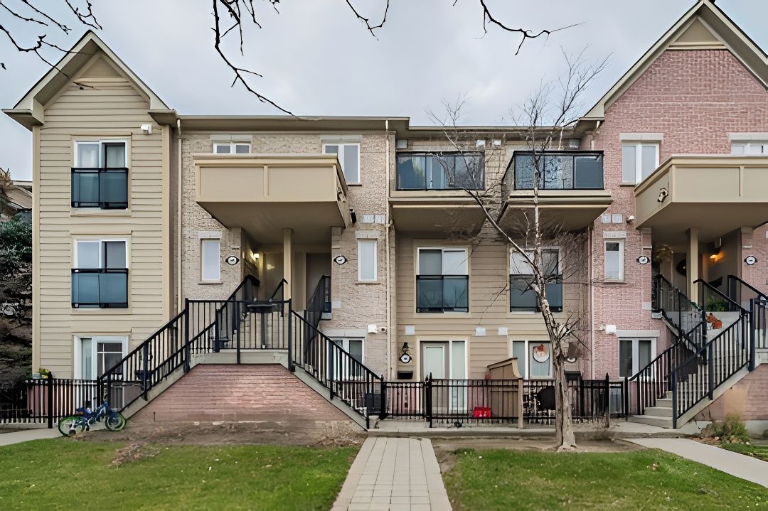 A multi-story residential building with a central staircase, balconies, and a brick facade.