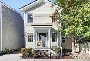 A two-story house with a front porch, a mailbox, and a small garden. - Savannah Reserve Whole House & Hot Tub Sleeps 12 (Savannah)