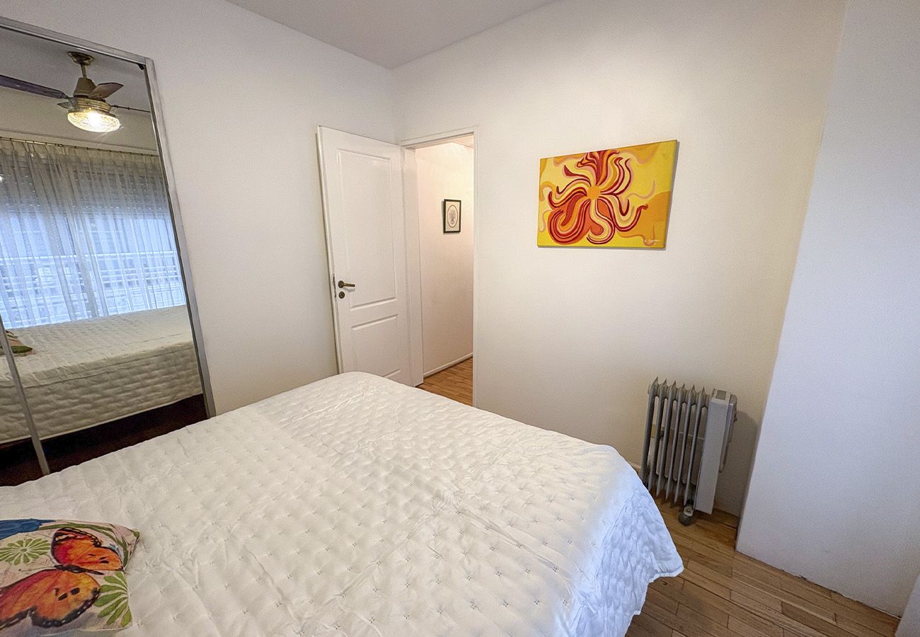Ein Schlafzimmer mit einem Bett, einem Heizkörper, einer Tür und einem Bild an der Wand.