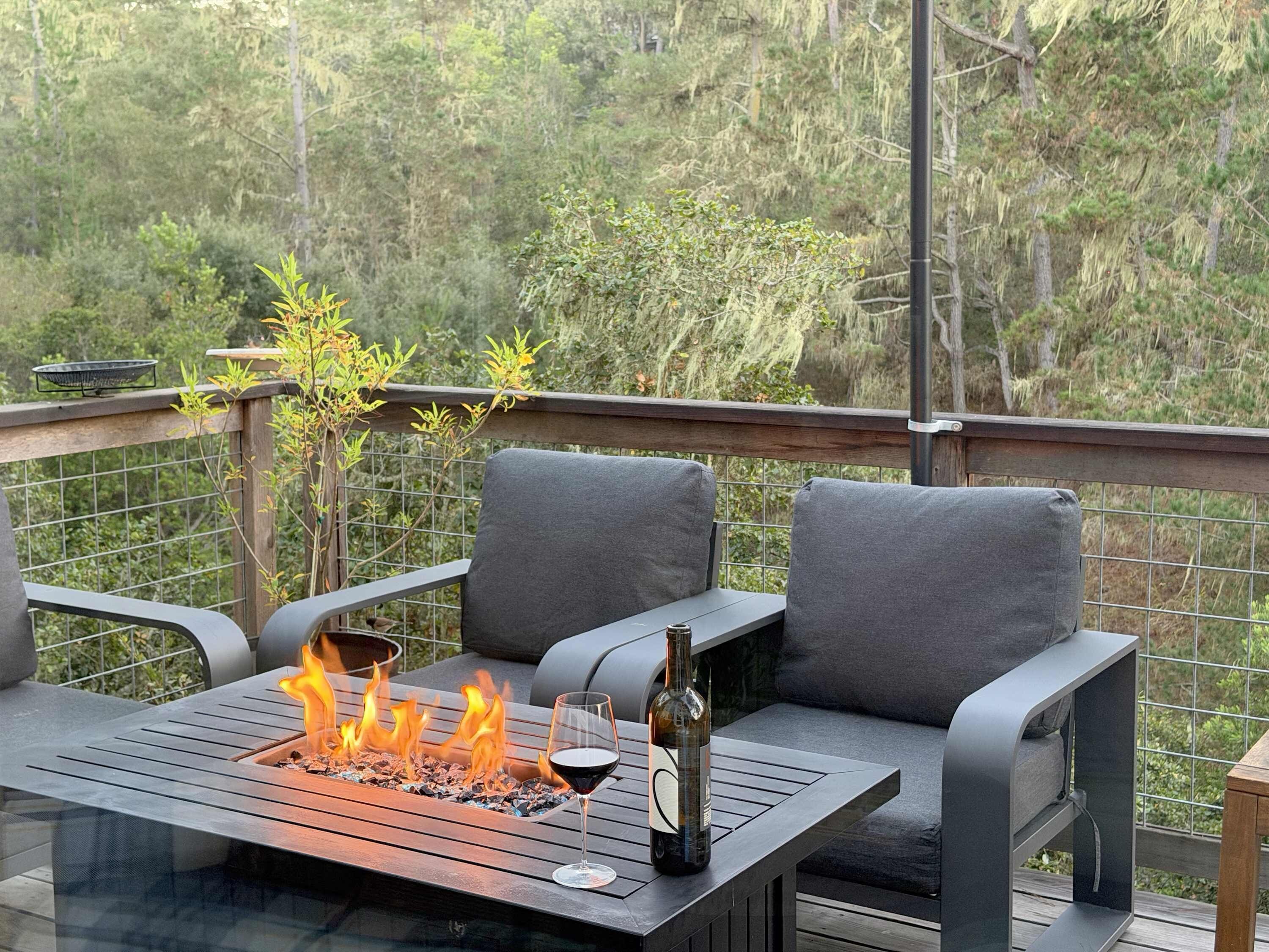 Un espacio exterior con asientos, una chimenea y una botella de vino.