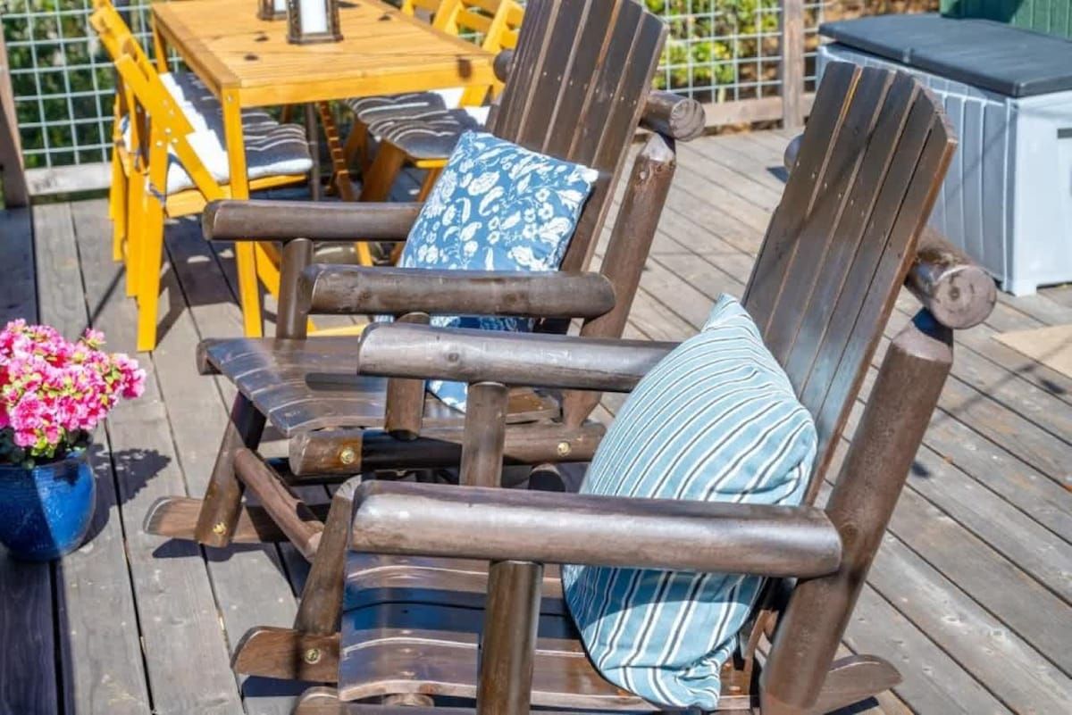 A wooden deck with a chair and a table.
