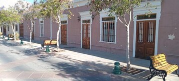 Una calle con edificios, árboles y bancos.
