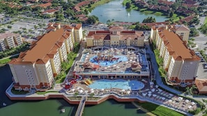 Resort com vários edifícios, área de piscina central com toboáguas e vista para a orla.