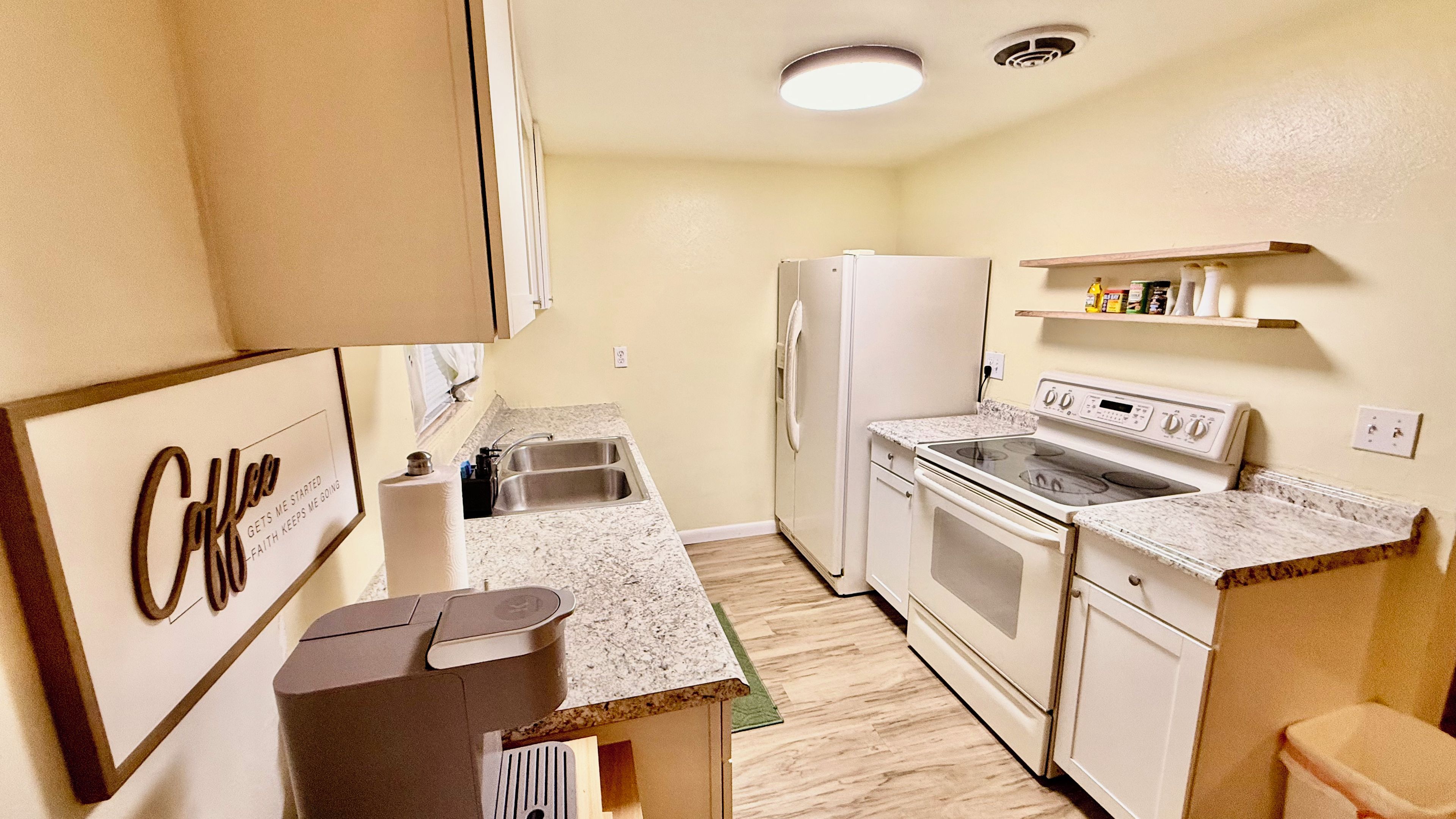 Cocina compacta con refrigerador, estufa y encimera.