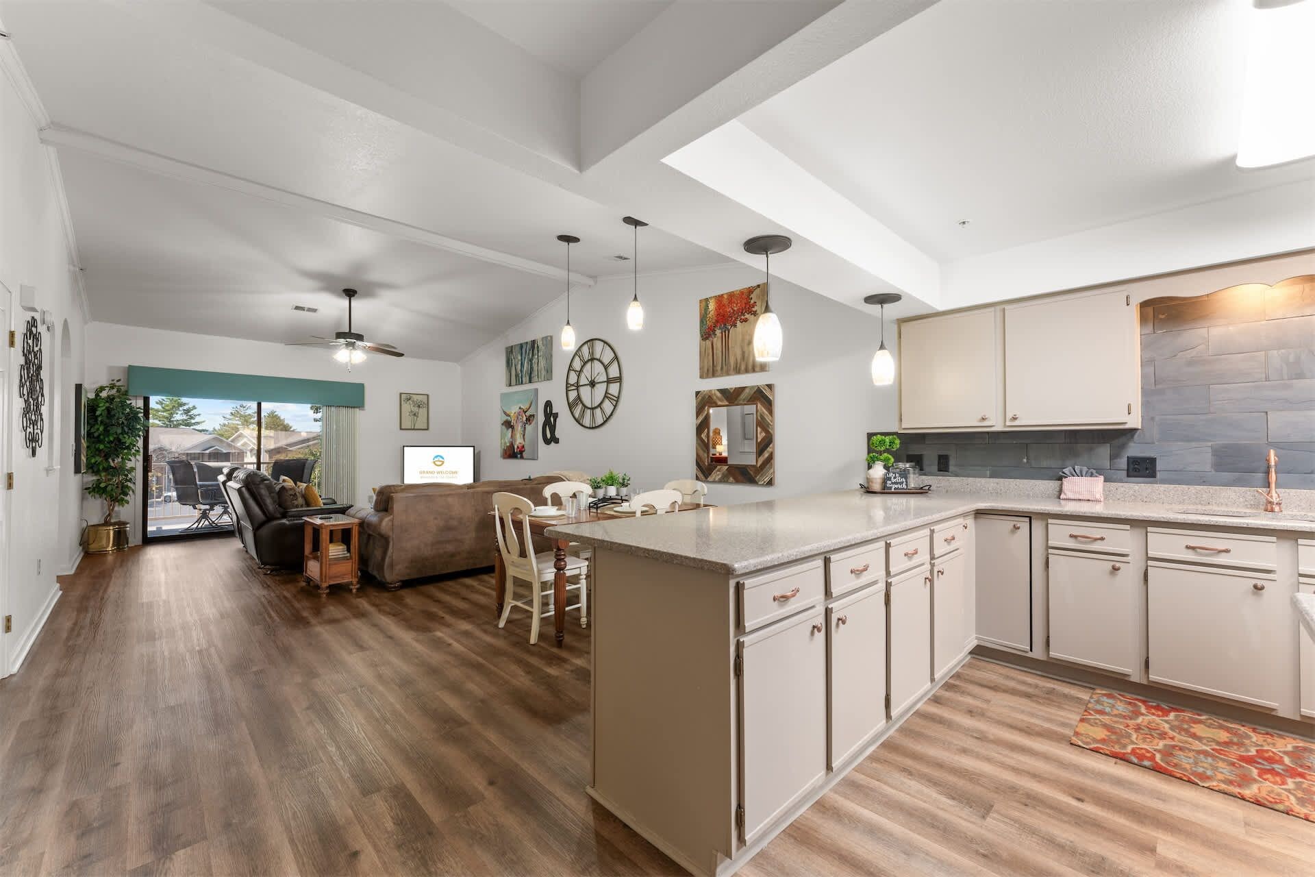 A spacious kitchen with a central island, wooden flooring, and modern cabinetry.