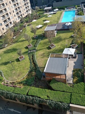 Un barrio residencial con piscina, césped verde y un edificio de techo inclinado.