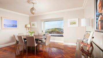 A dining area with a large table, chairs, and a view of the outdoors.