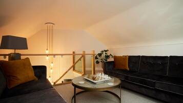Ein stilvolles Wohnzimmer mit einer Couch, einem Couchtisch und einer Lampe.