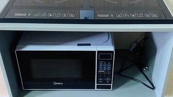 A kitchenette with a microwave and a built-in stove.