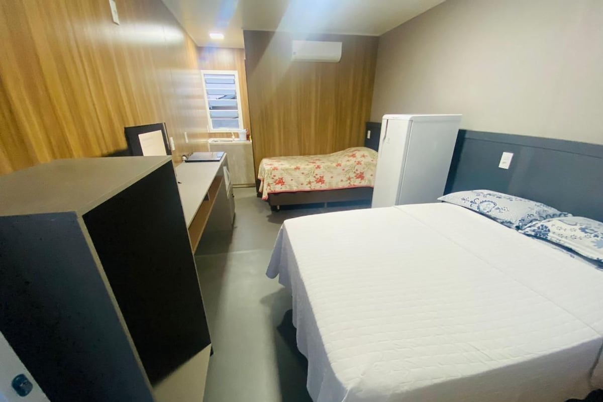 Una habitación de hotel con cama, escritorio y armario.