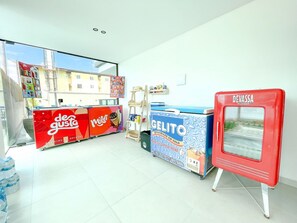 A gelato shop with a red freezer, a blue freezer, and a counter with a red sign. - Tangaroa #106 - Comfortable Apartment by Carpediem (Ipojuca)