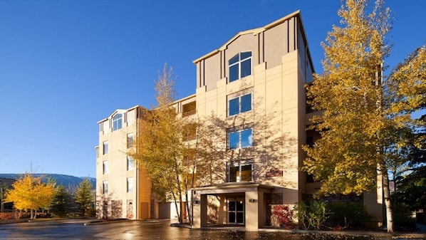Ein mehrgeschossiges Hotel mit modernem architektonischen Design, das einen zentralen Eingang und zahlreiche Fenster in jeder Etage aufweist.