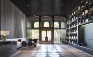 Eine moderne Lobby mit Schachbrettmuster-Boden, Kamin, Sitzgelegenheiten und Bücherregal.