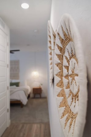 A corridor with a bed and a nightstand in the background.