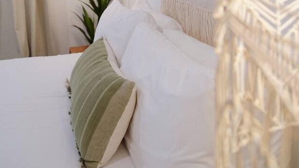 A bedroom with a bed, a hanging light fixture, a wall hanging, and a plant. - Cozy King Bed Suite | Near Shopping & DT Visalia (Visalia)