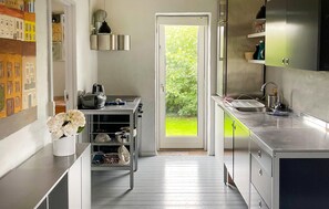 A modern kitchen with a built-in oven, a sink, and a window with a view of greenery. - Gorgeous home in Lemvig with house a panoramic view (Lemvig)