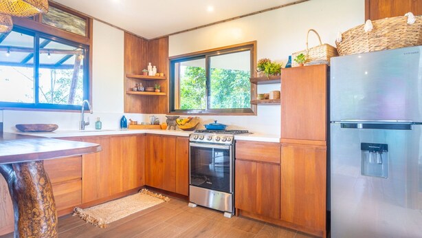 Een moderne keuken met houten kastjes, een roestvrijstalen fornuis en een koelkast.