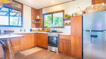 A modern kitchen with wooden cabinets, a stainless steel stove, and a refrigerator.