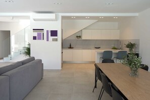 Een modern interieur met een eethoek, keuken en trap.