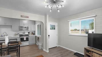 A modern kitchen with a microwave, oven, and dining area.
