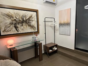 Un baño moderno con tocador de vidrio, toallero en la pared y zona de ducha.