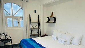 A hotel room with a bed, a chair, a ladder, and a window. - The Quetzal Cancun (Cancún)