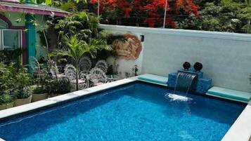 Ein rechteckiger Swimmingpool mit klarem, blauem Wasser, umgeben von einer weißen Poolterrasse.