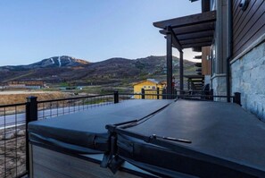 En balkong med utsikt över ett berg och en gul byggnad i bakgrunden.