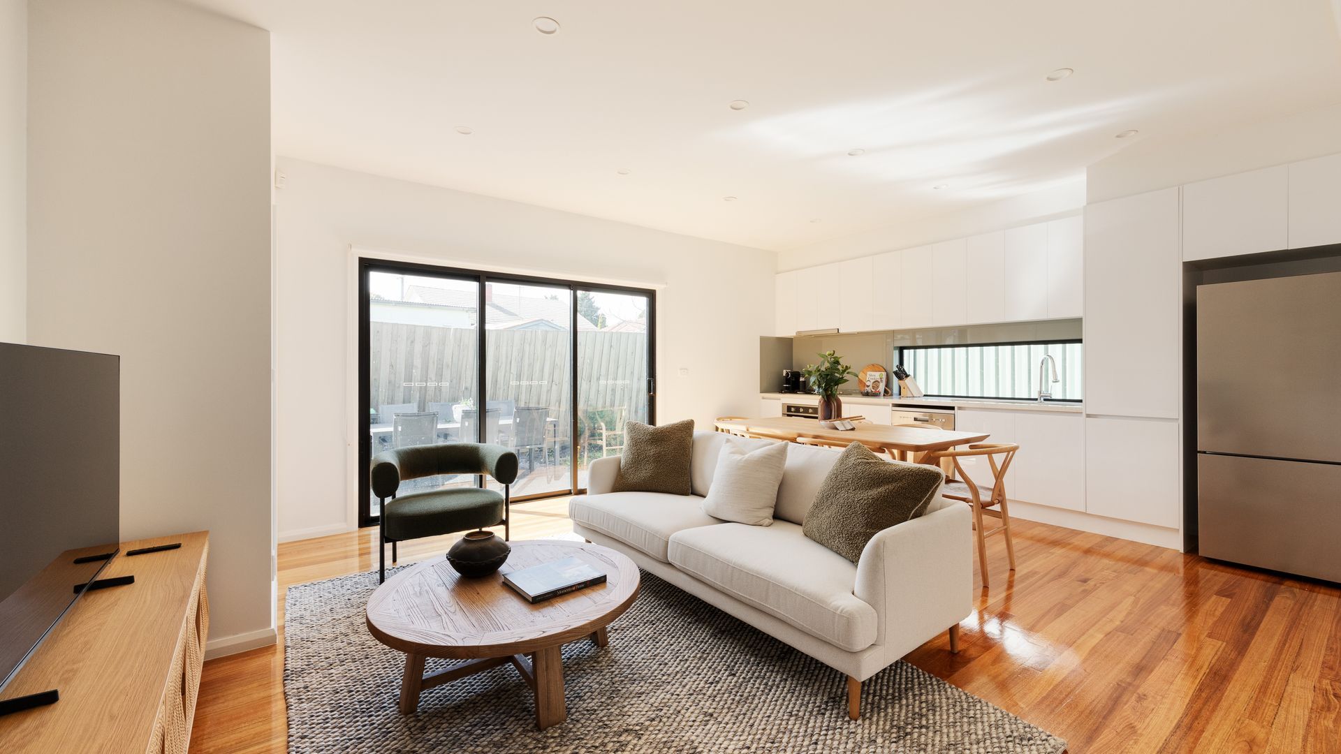 A modern living room with a sofa, coffee table, and a TV.