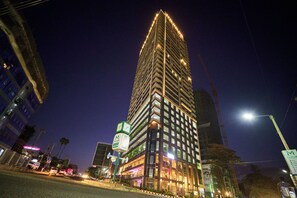Un immeuble de grande hauteur, doté de nombreux étages, de fenêtres illuminées et d’un beffroi remarquable.