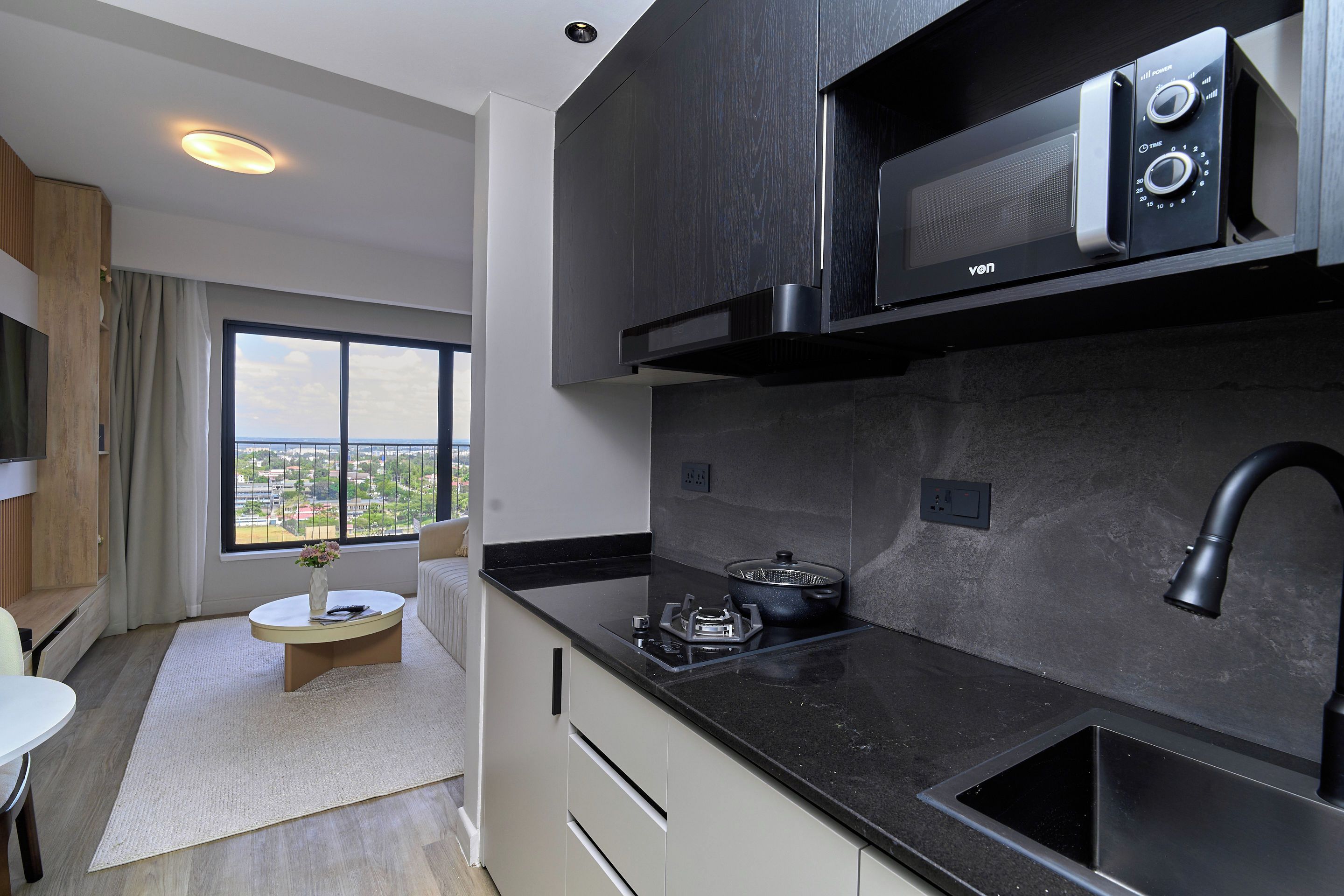 A modern kitchen with a built-in microwave, stove, and sink.
