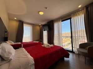 A hotel room with two beds, a TV, and a balcony with a view. - Hotel San Miguel Cusco (CUSCO)