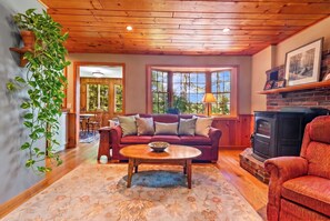 A cozy living room with a fireplace, a sofa, a coffee table, and a dining area.