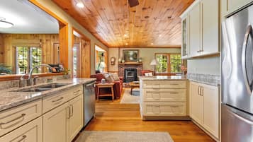 Eine Küche mit Holzausstattung, einem Edelstahlkühlschrank und einem Kamin.