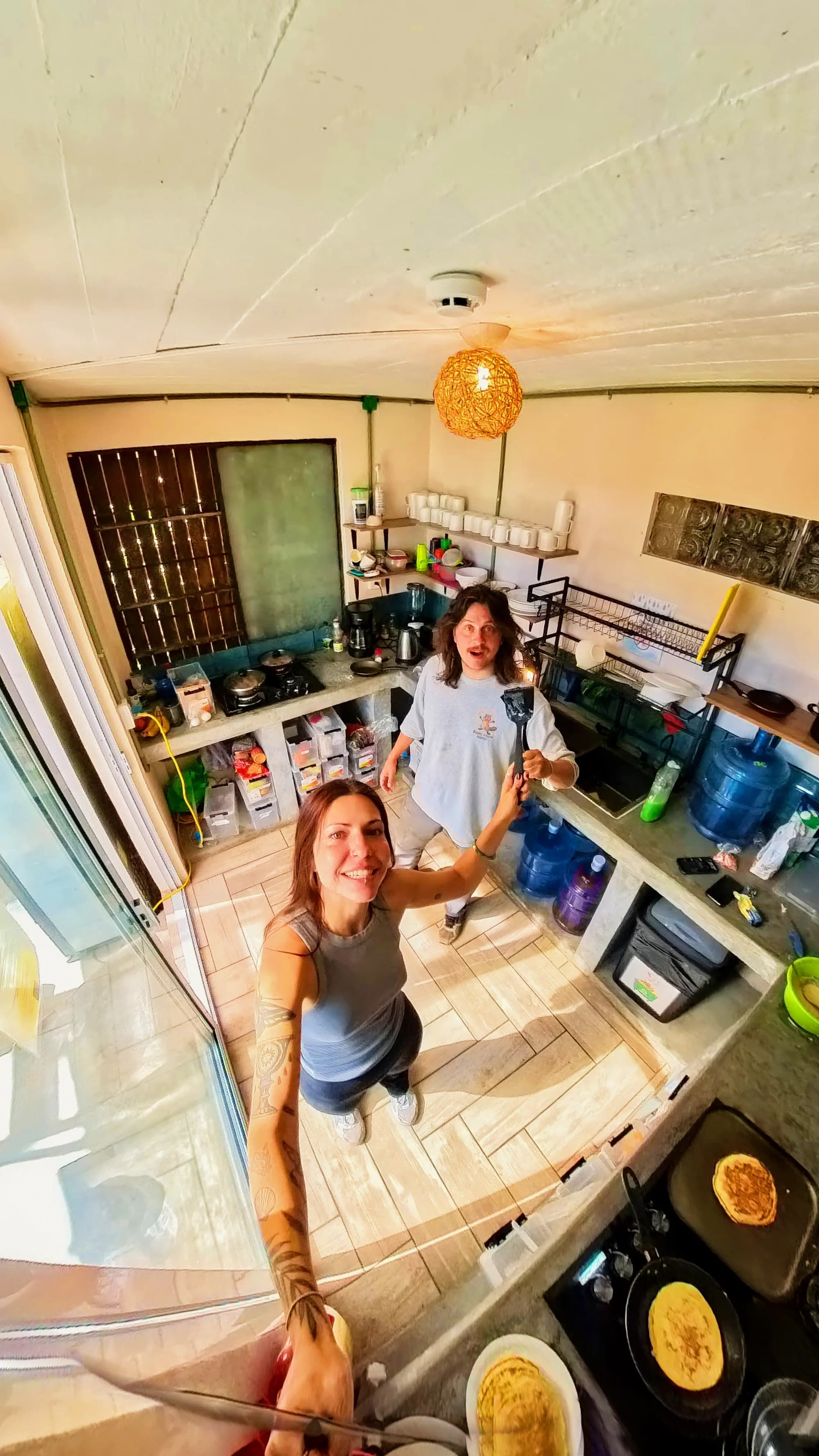 Una cocina con estufa, lavamanos y diversos utensilios.