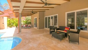 A covered outdoor area with a pool, seating, and a ceiling fan. - Private Tropical Villa • Pool • Near Conchal & Flamingo (Brasilito)