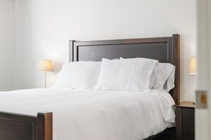A neatly made bed with white linens in a hotel room. - Core Downtown condo with 2 bedroom 2  full bathrooms full equipment kitchen (Edmonton)