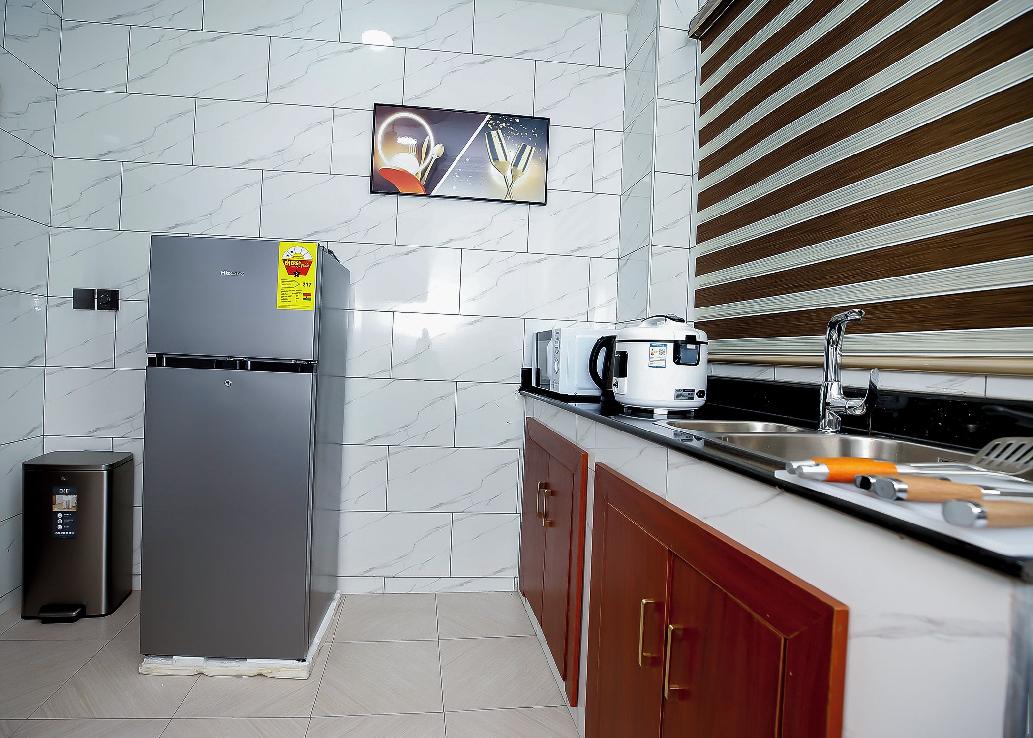 A modern kitchen with a stainless steel refrigerator, a microwave, and a sink.