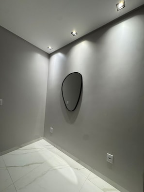A room with a tiled floor, recessed ceiling lights, and a wall-mounted light fixture. - Mangrove Refuge: A new, high-end home in the Brazilian Caribbean. (Barra Grande)