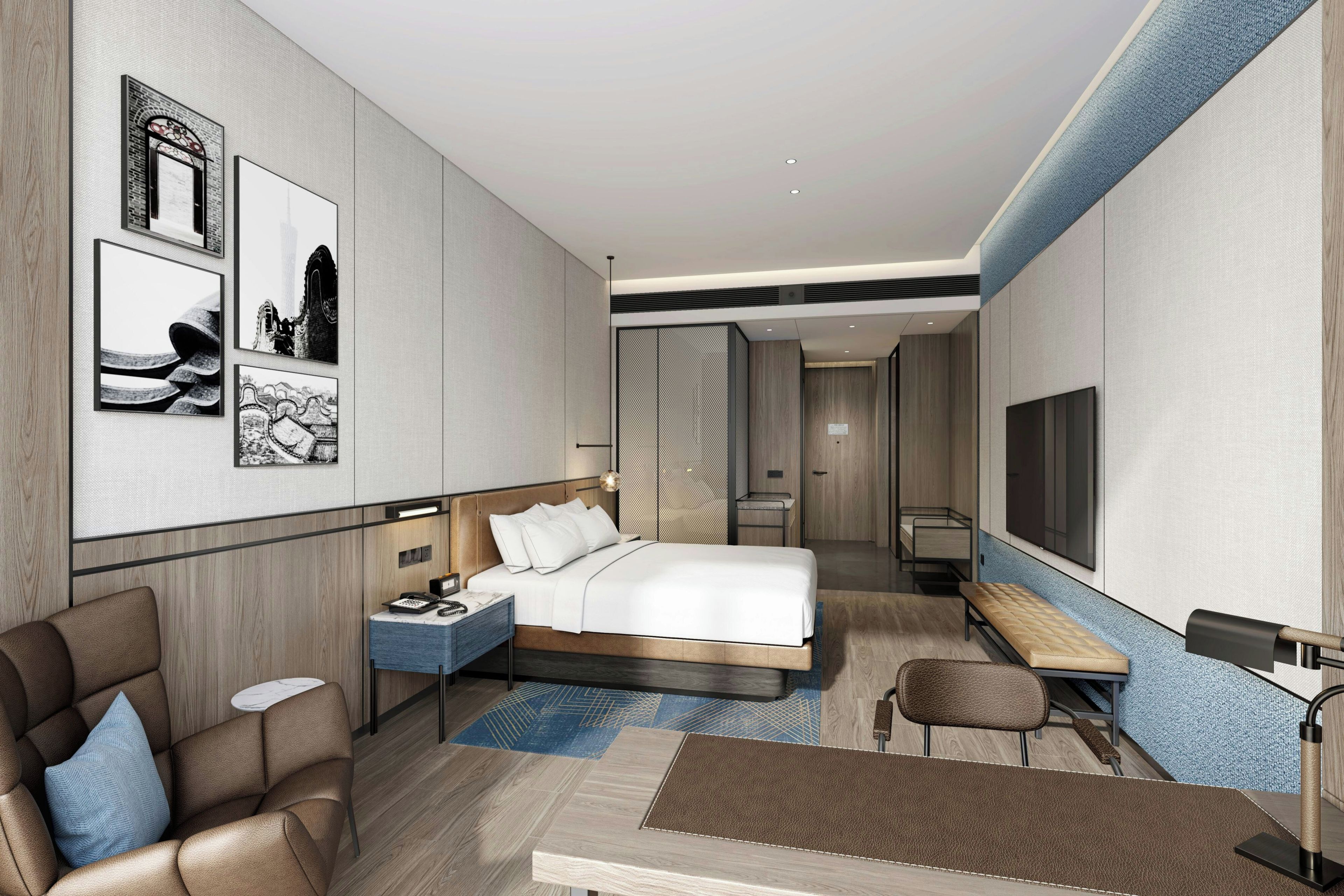 A modern hotel room with a bed, seating area, and a TV.
