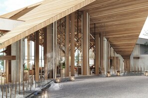 A modern interior with a high ceiling, wooden beams, and a central open space with a water feature.