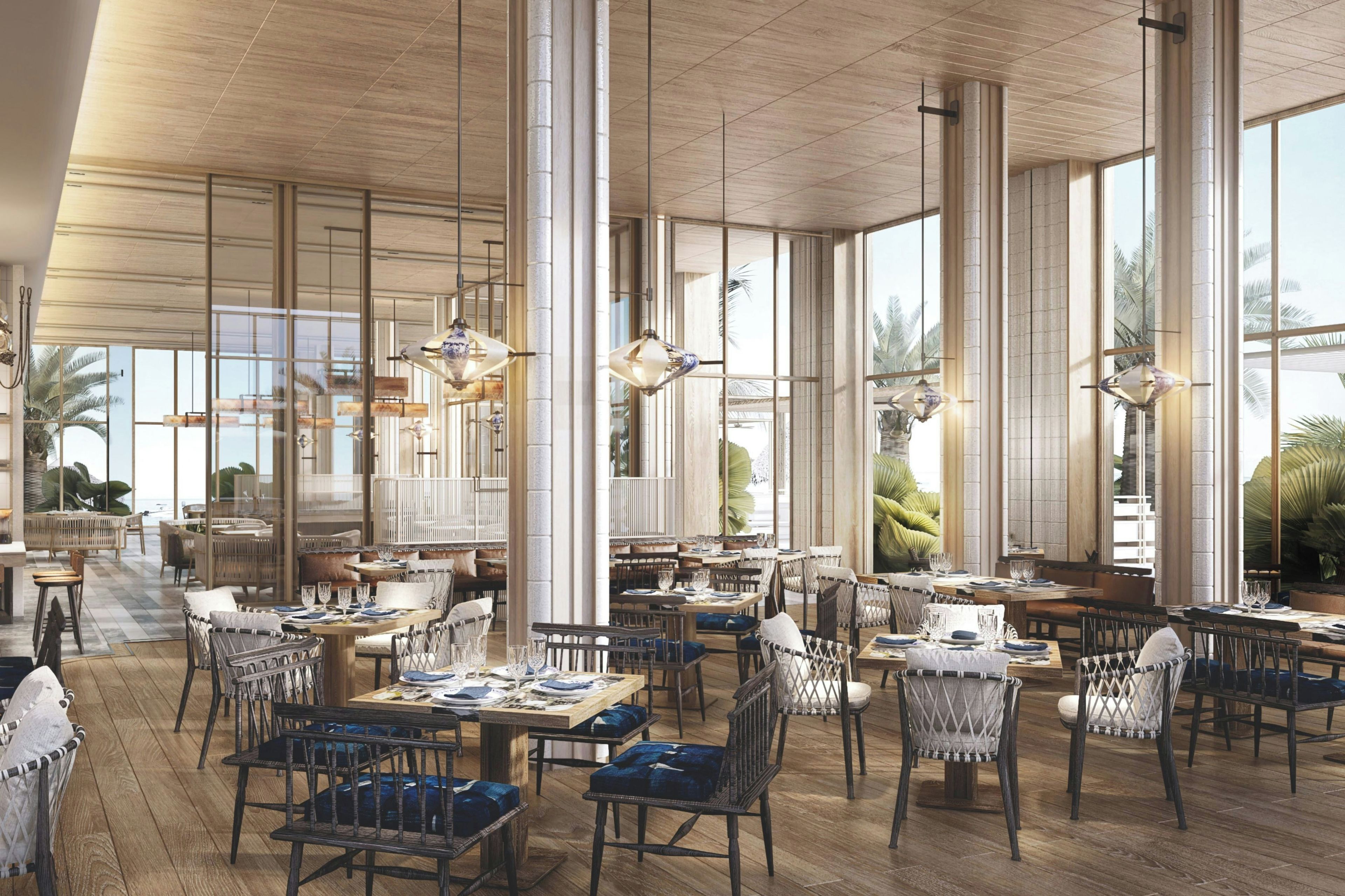 A spacious restaurant with high ceilings, large windows, and modern furnishings.