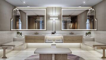 A modern bathroom with a central sink, two mirrors, and a round table.