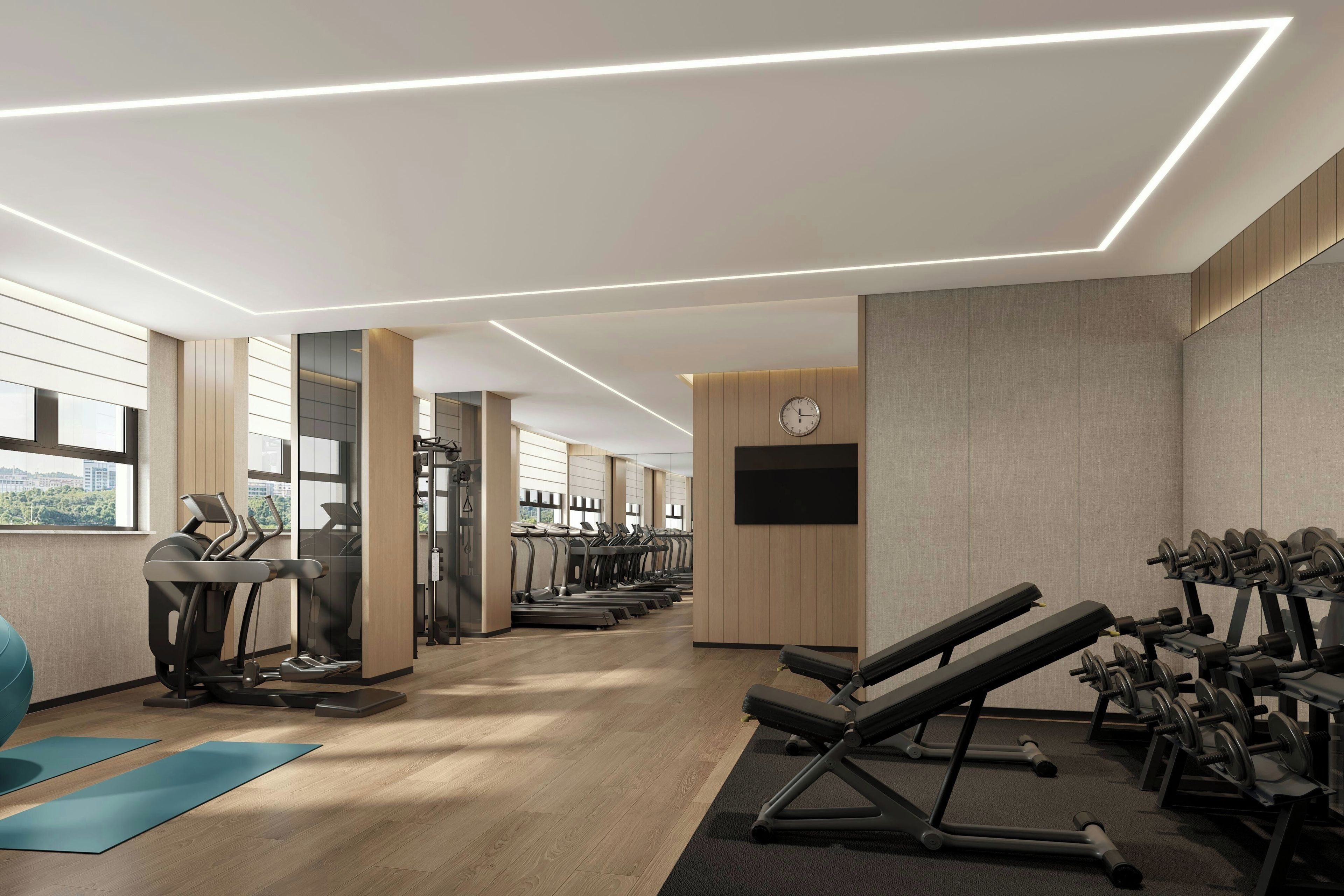 Un gimnasio moderno con cintas de correr, máquinas de pesas y un amplio ventanal.