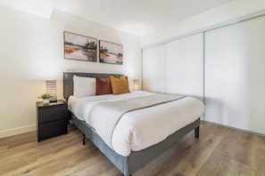 Ein modernes Schlafzimmer mit einem Bett, Nachttischen und Bildern an der Wand.