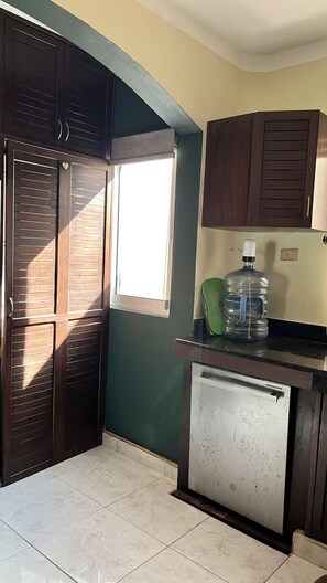 A kitchen with a refrigerator, a water dispenser, and a window. - Casa Corazon: a tropical boutique villa by the golf course, with a pool and a nearby beach (puerto aventuras)